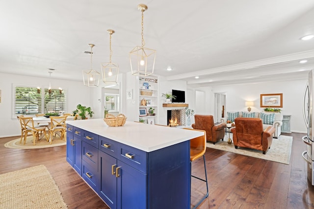 3006 Ann Arbor Dr, Houston, TX 77063 - kitchen with blue cabinets, dark wood-type flooring, a breakfast bar area, a lit fireplace, and a kitchen island