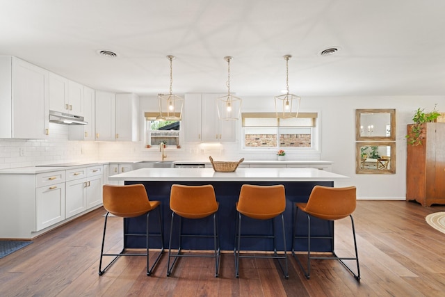 3006 Ann Arbor Dr, Houston, TX 77063 - kitchen with decorative backsplash, a kitchen island, a kitchen bar, and light countertops