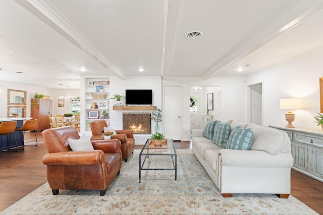 3006 Ann Arbor Dr, Houston, TX 77063 - living room with beamed ceiling, wood finished floors, a lit fireplace, recessed lighting, and a chandelier