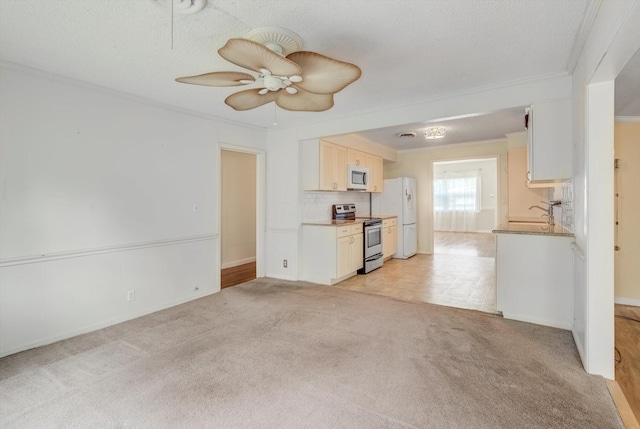 211 Magnolia St, Lake Jackson, TX 77566 - kitchen with stainless steel electric range oven, freestanding refrigerator, ornamental molding, light colored carpet, and ceiling fan