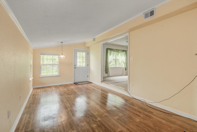 211 Magnolia St, Lake Jackson, TX 77566 - spare room with ornamental molding, wood finished floors, vaulted ceiling, and a textured ceiling