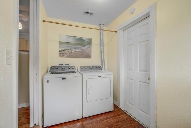 211 Magnolia St, Lake Jackson, TX 77566 - laundry room featuring washing machine and clothes dryer and wood finished floors