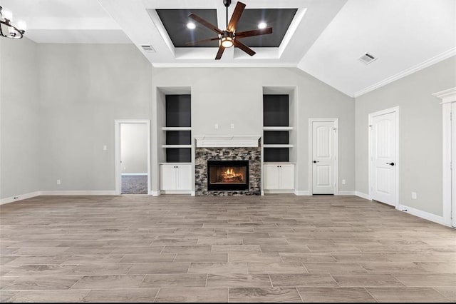 427 Rd 66111, Dayton, TX 77535 - unfurnished living room featuring ceiling fan, a stone fireplace, built in features, light wood-style floors, and crown molding