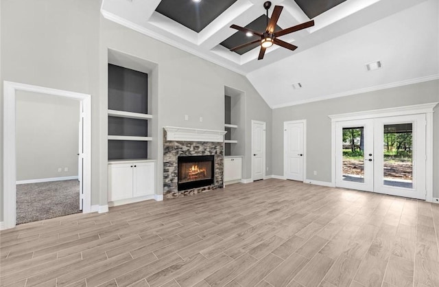 427 Rd 66111, Dayton, TX 77535 - unfurnished living room with ceiling fan, a stone fireplace, coffered ceiling, light wood finished floors, and french doors