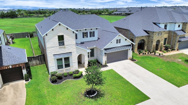 1831 Golden Cape Dr, Katy, TX 77494 - french country inspired facade with stone siding, roof with shingles, concrete driveway, and an attached garage