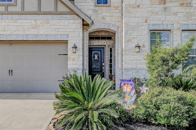 28638 Monarch Cliffs Dr, Fulshear, TX 77441 - doorway to property with stone siding, a garage, and concrete driveway