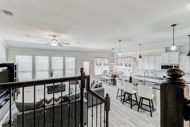 28638 Monarch Cliffs Dr, Fulshear, TX 77441 - living area featuring ceiling fan, crown molding, and light wood finished floors
