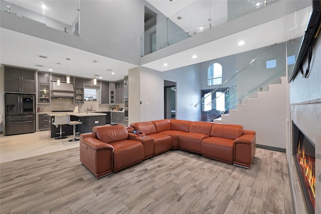 5215 Kelso St, Houston, TX 77021 - living area with a towering ceiling, light wood-style floors, stairway, and recessed lighting