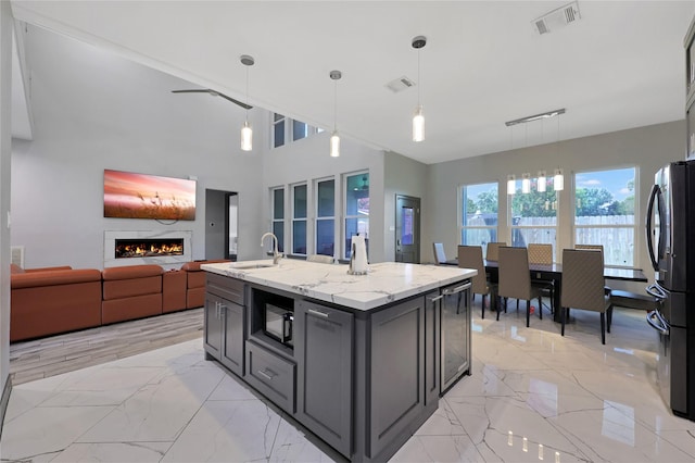 5215 Kelso St, Houston, TX 77021 - kitchen with black microwave, freestanding refrigerator, a fireplace, light marble finish floors, and open floor plan