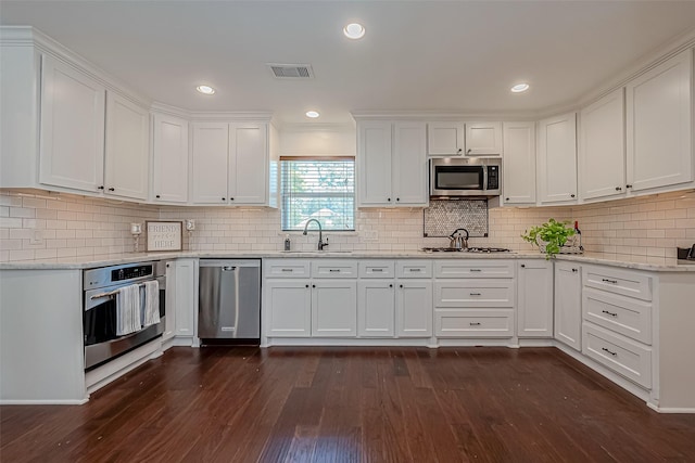 1714 Maux Dr, Houston, TX 77043 - kitchen featuring stainless steel appliances, white cabinetry, dark wood-style flooring, tasteful backsplash, and light stone countertops