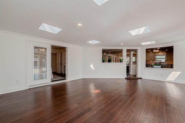 1714 Maux Dr, Houston, TX 77043 - unfurnished living room with a skylight, dark wood-type flooring, ceiling fan, recessed lighting, and crown molding