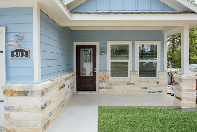 803 Cherokee Dr, Conroe, TX 77316 - doorway to property with board and batten siding, covered porch, and stone siding