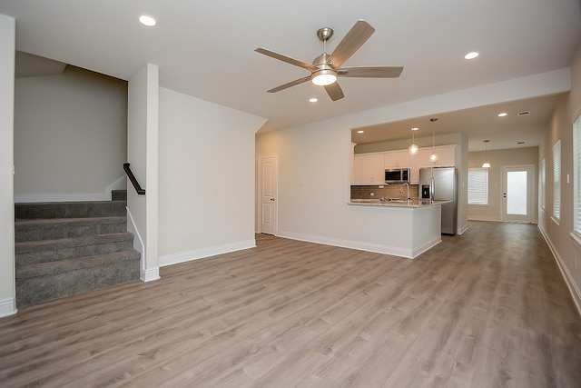 803 Cherokee Dr, Conroe, TX 77316 - unfurnished living room with a ceiling fan, light wood-style flooring, recessed lighting, and stairway