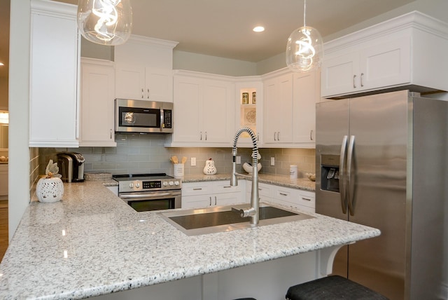 803 Cherokee Dr, Conroe, TX 77316 - kitchen with stainless steel appliances, white cabinets, light stone counters, and recessed lighting