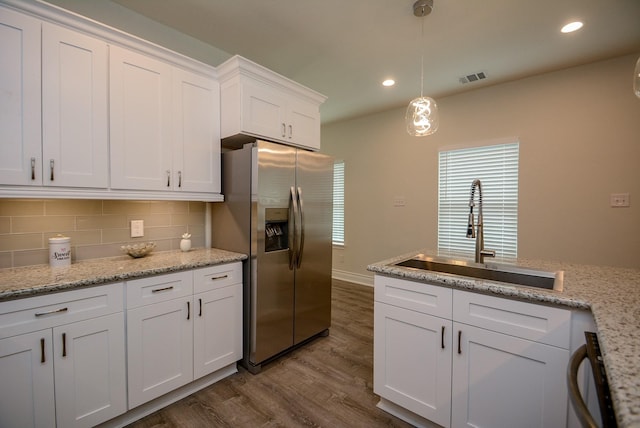 803 Cherokee Dr, Conroe, TX 77316 - kitchen featuring stainless steel fridge with ice dispenser, dark wood-type flooring, white cabinets, decorative backsplash, and recessed lighting