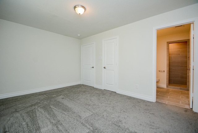 803 Cherokee Dr, Conroe, TX 77316 - unfurnished bedroom featuring carpet floors and ensuite bathroom