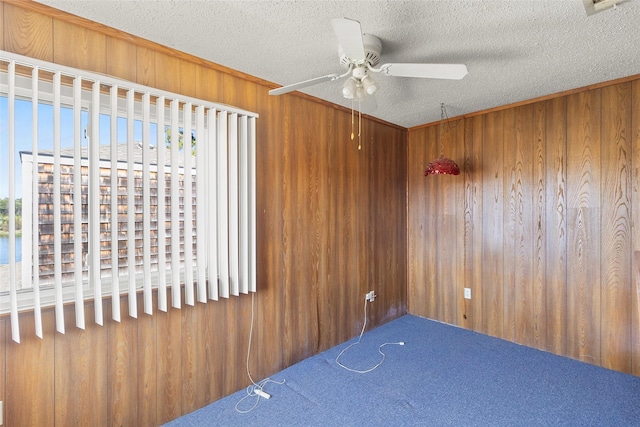 H6 The Bch Unit H6, Huntsville, TX 77320 - empty room featuring wood walls, a ceiling fan, a textured ceiling, and carpet flooring