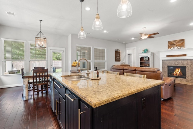 103 Jacks Corner Dr, Montgomery, TX 77316 - kitchen featuring a tiled fireplace, a ceiling fan, recessed lighting, dark wood-style flooring, and decorative light fixtures