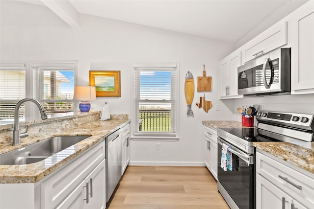 4630 Blue Water Hwy, Freeport, TX 77541 - kitchen with stainless steel appliances, light wood-style flooring, white cabinetry, and light stone counters