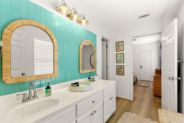 4630 Blue Water Hwy, Freeport, TX 77541 - full bathroom featuring ensuite bath, double vanity, and wood finished floors