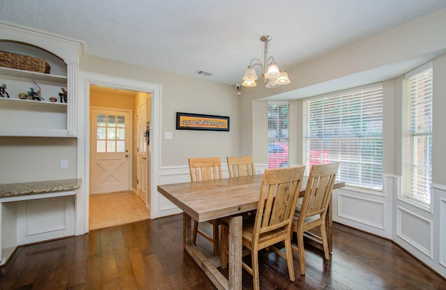6711 Pebble Beach Dr, Houston, TX 77069 - dining space with a decorative wall, dark wood-style flooring, a chandelier, and wainscoting