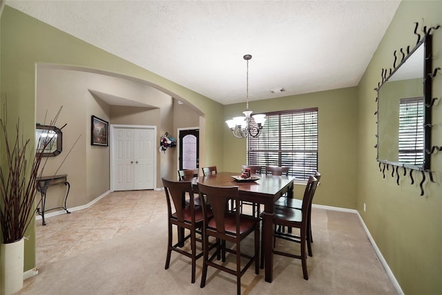 18 S April Mist Cir, The Woodlands, TX 77385 - dining space with arched walkways, a chandelier, light colored carpet, and light tile patterned floors