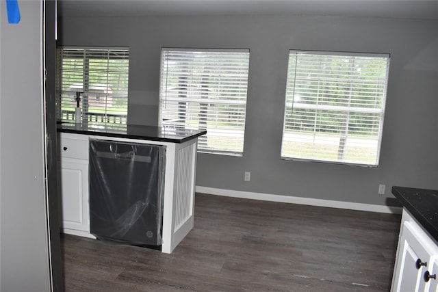 25 Wood Gln, Trinity, TX 75862 - kitchen featuring dishwashing machine, dark countertops, dark wood-type flooring, and white cabinetry