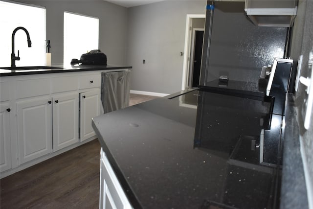 25 Wood Gln, Trinity, TX 75862 - kitchen featuring dark countertops, dark wood-style floors, white cabinets, and fridge