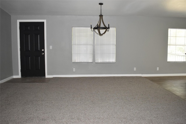 25 Wood Gln, Trinity, TX 75862 - spare room with a chandelier and dark colored carpet