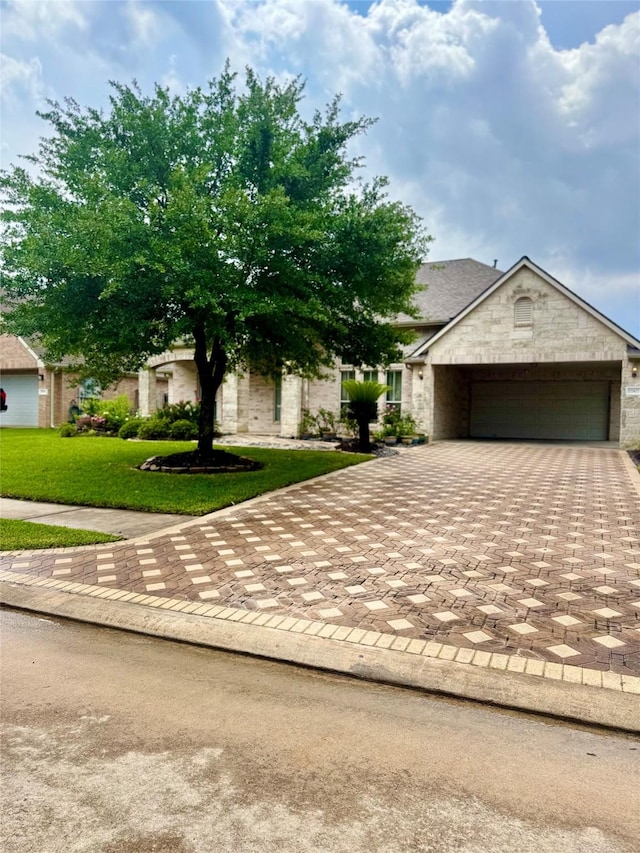 17907 Camp Cove Dr, Cypress, TX 77429 - view of property hidden behind natural elements featuring decorative driveway, a front lawn, an attached garage, and stone siding