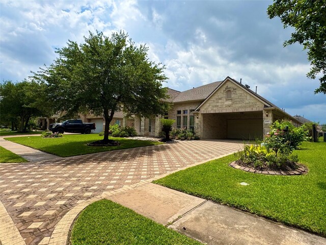 17907 Camp Cove Dr, Cypress, TX 77429 - view of front of property with decorative driveway, an attached garage, stone siding, and a front yard
