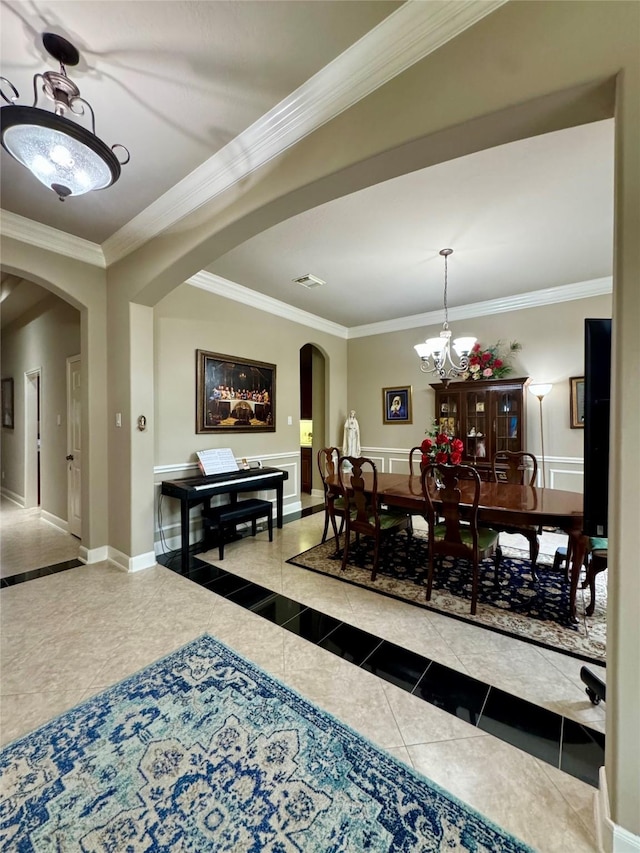 17907 Camp Cove Dr, Cypress, TX 77429 - dining area featuring arched walkways, ornamental molding, tile patterned flooring, inlaid floor details, and a chandelier
