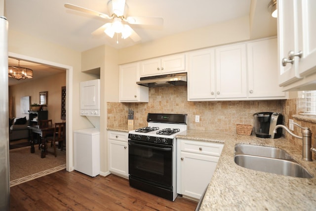 1015 Tri Oaks Ln Unit 23, Houston, TX 77043 - kitchen featuring range with gas stovetop, under cabinet range hood, stacked washer / drying machine, ceiling fan, and white cabinets