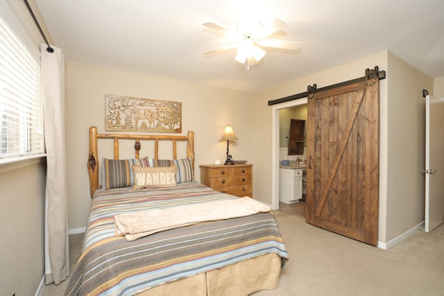 1015 Tri Oaks Ln Unit 23, Houston, TX 77043 - bedroom with a barn door, light colored carpet, ensuite bathroom, and a ceiling fan