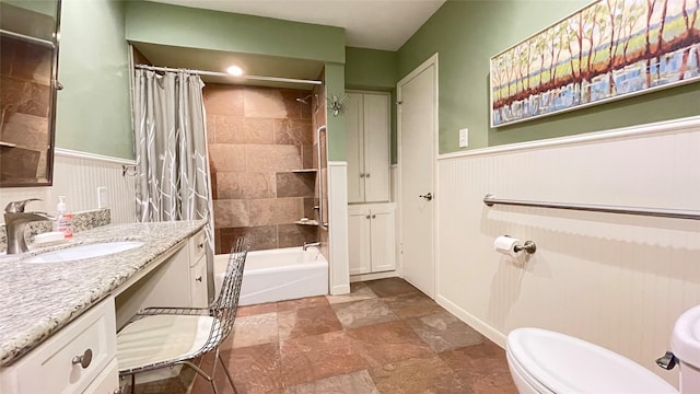 1015 Tri Oaks Ln Unit 23, Houston, TX 77043 - full bathroom featuring vanity, shower / bath combo with shower curtain, wainscoting, and stone finish floors
