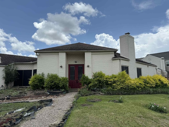 2302 Ashford Hollow Ln, Houston, TX 77077 - view of front of house with brick siding, a front yard, a chimney, french doors, and roof with shingles