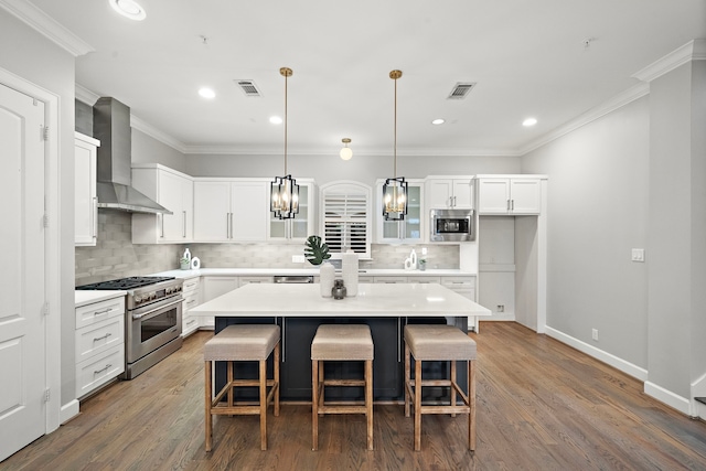 1829 W Main St Unit C, Houston, TX 77098 - kitchen with stainless steel appliances, wall chimney exhaust hood, a breakfast bar, tasteful backsplash, and recessed lighting