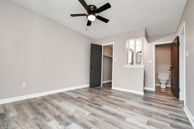 1505 Ward Rd Unit 182, Baytown, TX 77520 - unfurnished bedroom with wood finished floors, a textured ceiling, a walk in closet, a closet, and a ceiling fan