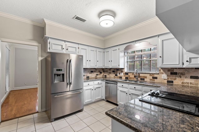 3318 Teawick Ct, Houston, TX 77068 - kitchen featuring stainless steel appliances, light tile patterned floors, dark stone countertops, tasteful backsplash, and crown molding