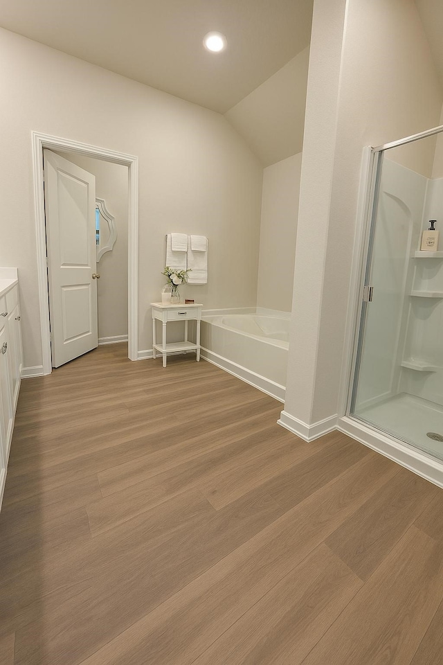 11407 Prairie Walk Dr, Houston, TX 77048 - bathroom featuring a shower stall, vanity, wood finished floors, a bath, and lofted ceiling