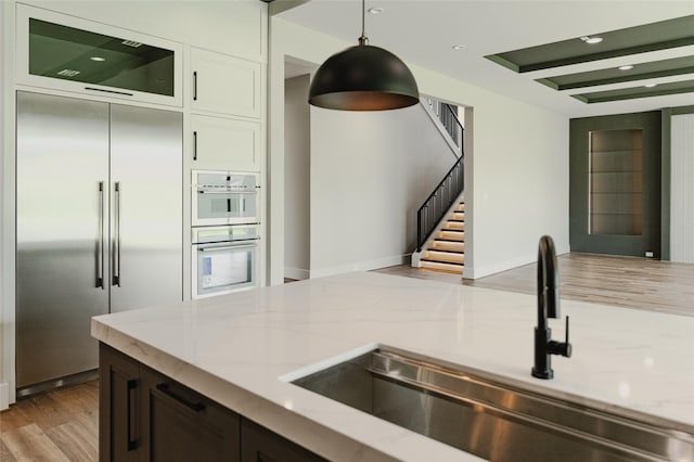 7302 Schiller St, Houston, TX 77055 - kitchen featuring built in fridge, light stone countertops, white double oven, and recessed lighting