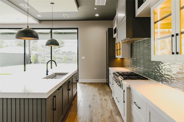 7302 Schiller St, Houston, TX 77055 - kitchen with stainless steel gas cooktop, tasteful backsplash, plenty of natural light, light wood-style floors, and recessed lighting
