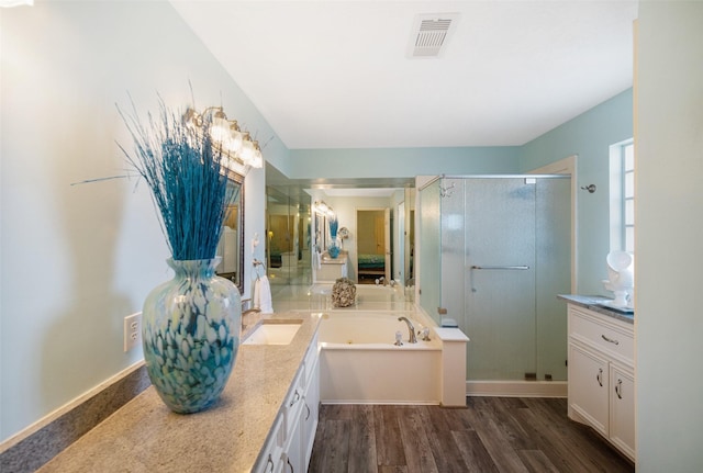 17383 Harbor Dr, Montgomery, TX 77356 - bathroom with vanity, a stall shower, a garden tub, and wood finished floors