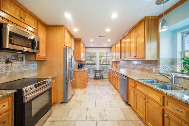 17383 Harbor Dr, Montgomery, TX 77356 - kitchen featuring stainless steel appliances, brown cabinetry, tasteful backsplash, recessed lighting, and light stone countertops