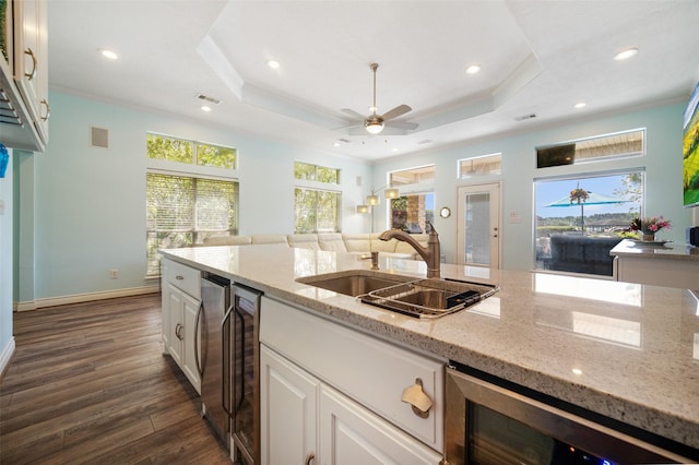 17383 Harbor Dr, Montgomery, TX 77356 - kitchen with beverage cooler, dark wood-style flooring, ornamental molding, light stone counters, and white cabinets
