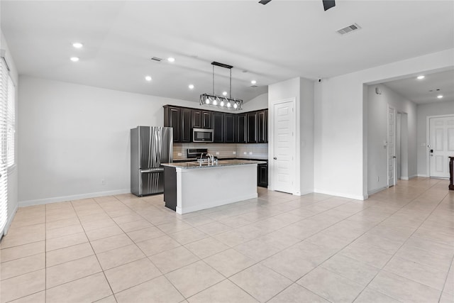19815 Caprock Falls Ct, Cypress, TX 77433 - kitchen with appliances with stainless steel finishes, tasteful backsplash, light tile patterned floors, recessed lighting, and a center island with sink