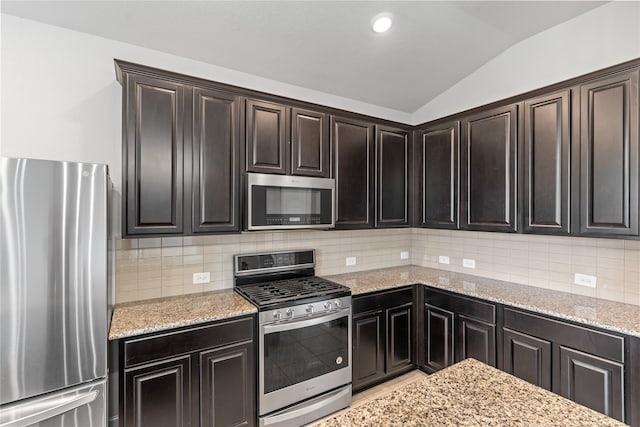 19815 Caprock Falls Ct, Cypress, TX 77433 - kitchen featuring stainless steel appliances, lofted ceiling, light stone counters, tasteful backsplash, and recessed lighting