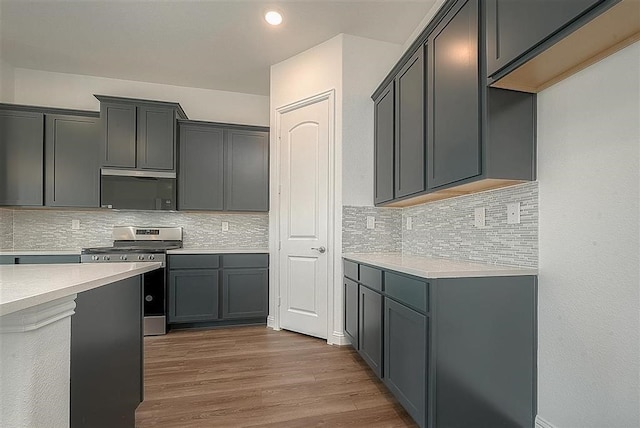 2040 Terra Rose Dr, Katy, TX 77493 - kitchen featuring stainless steel gas range oven, decorative backsplash, wood finished floors, light countertops, and recessed lighting
