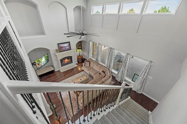 3211 Lakes Of Katy Ln, Katy, TX 77493 - staircase with wood finished floors, a lit fireplace, ceiling fan, and a high ceiling