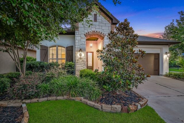 15 Floral Hills Ln, Fulshear, TX 77441 - view of front of home featuring stone siding, an attached garage, concrete driveway, and stucco siding